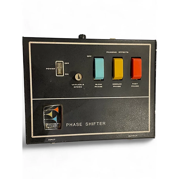 A vintage phase shifter effects unit with a black panel, labeled switches for power, variable speed, and three colored buttons for slow, medium, and fast phase settings. The brand logo is displayed in the lower left corner.