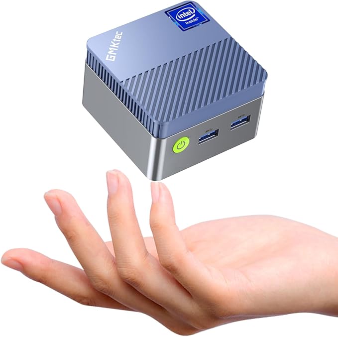 A small, gray mini PC with Intel branding appears to float above an open human hand, with two USB ports and a green power button visible on the front.