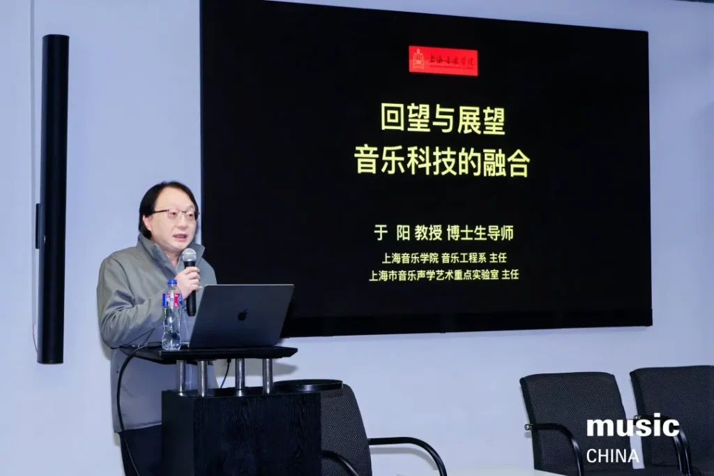 Six men sit on stage in chairs, engaged in a panel discussion. Behind them is a large screen displaying headshots and names in Chinese, with abstract purple graphics. The words “music CHINA” appear in the bottom right corner.