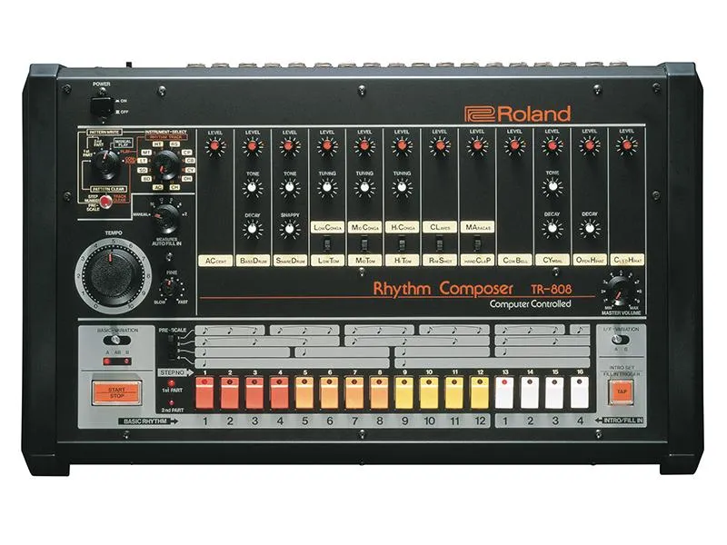 Front view of a Roland TR-808 Rhythm Composer drum machine featuring multiple knobs, sliders, and colored buttons arranged in rows for controlling and sequencing drum sounds.