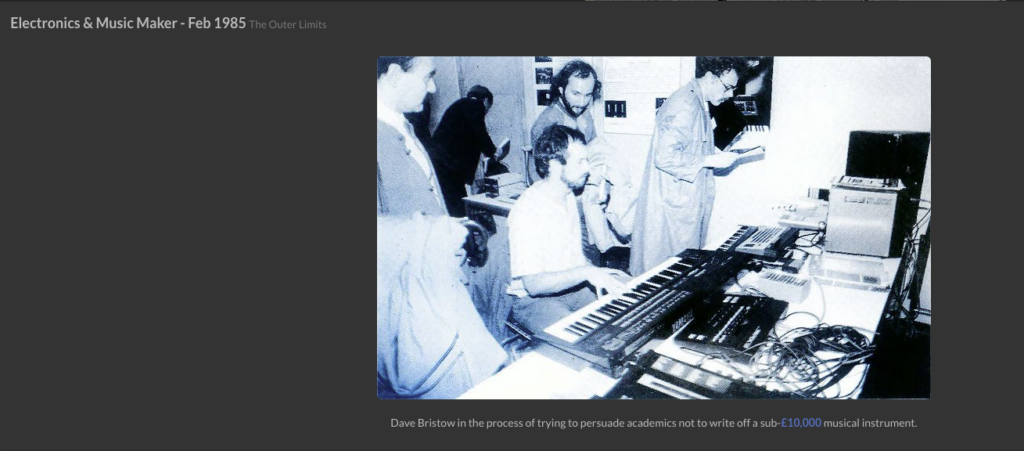 Four people in a studio work with synthesizers and electronic equipment. One person is seated, playing a keyboard, while the others observe or take notes. The image has a blue tint and appears to be from the 1980s.