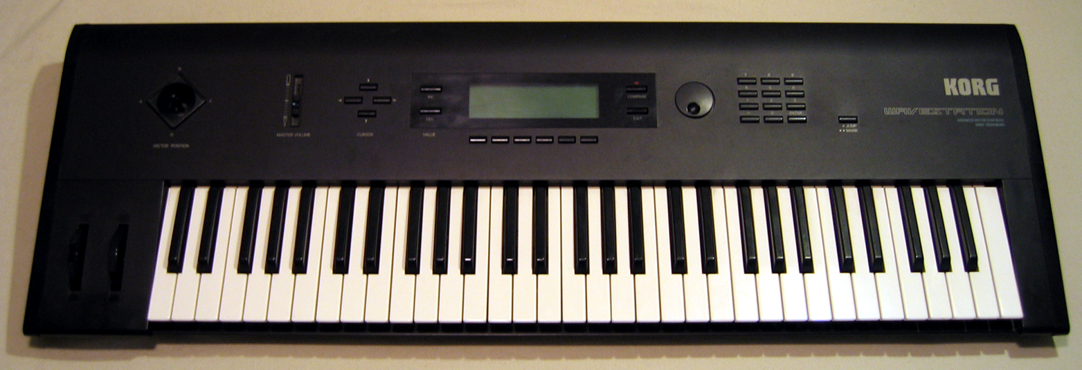 A black Korg synthesizer keyboard with various buttons, knobs, a small display screen, and a standard set of piano keys, photographed from above on a light-colored surface.
