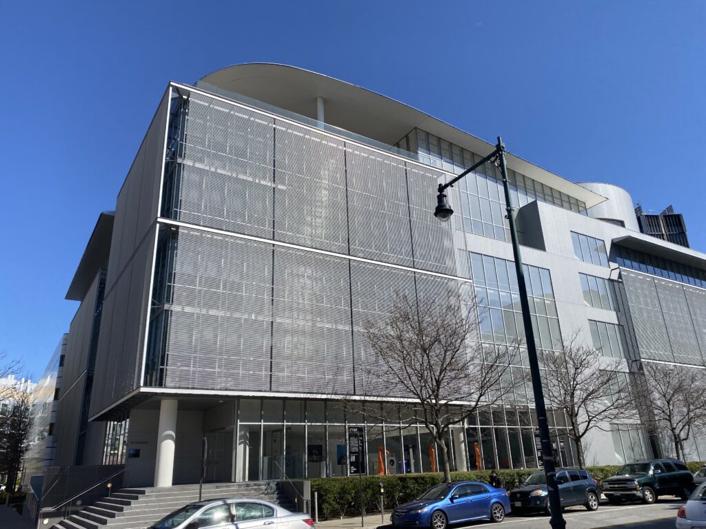 Photo of the MIT Media Lab a gleaming silver modern building shining in the spring sun.