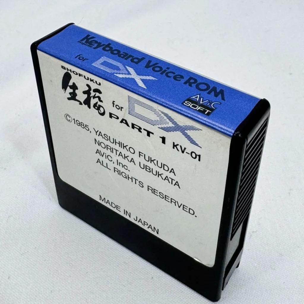 A rectangular vintage computer cartridge labeled Keyboard Voice ROM for DX PART 1 with Japanese text, credits, and a Made in Japan note, featuring a blue and white design.