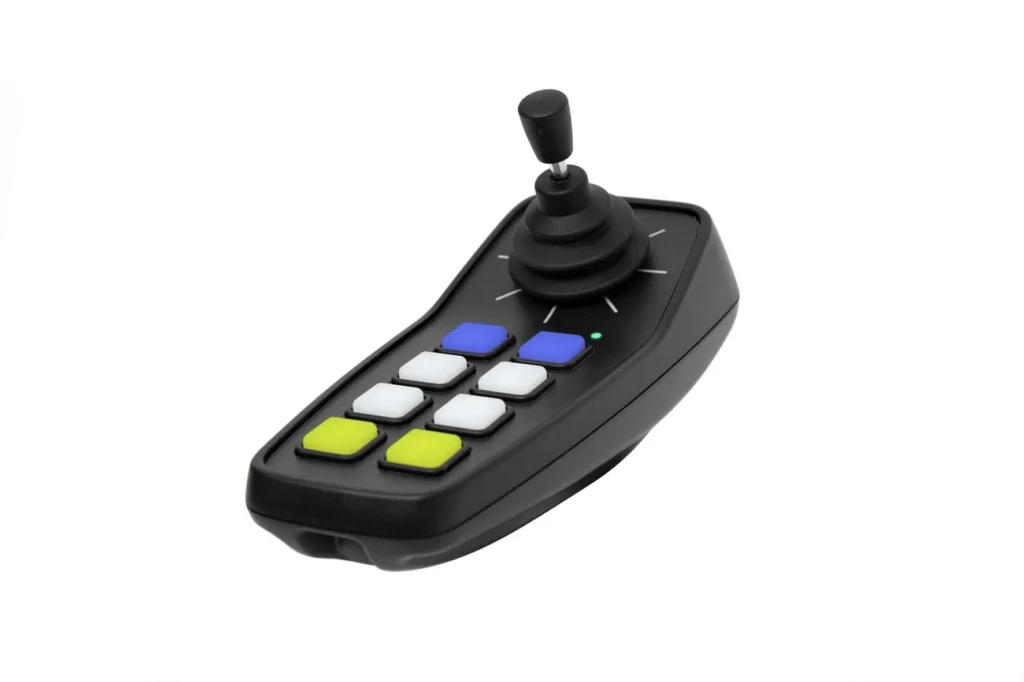 A black joystick controller with a single stick and ten colored buttons (white, blue, green, and yellow) on its surface, set against a white background.