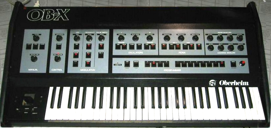 A vintage Oberheim OB-X synthesizer featuring black and white keys, various controls, knobs, and switches on a gray and black control panel with OB-X and Oberheim logos.
