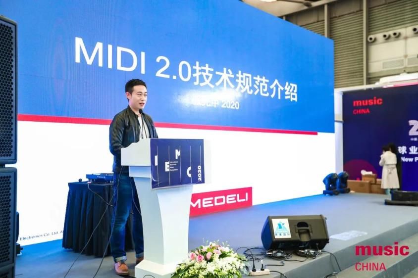 A man stands at a podium giving a presentation on MIDI 2.0 technology at a music industry event. Large screens and banners with the music CHINA logo are visible in the background.